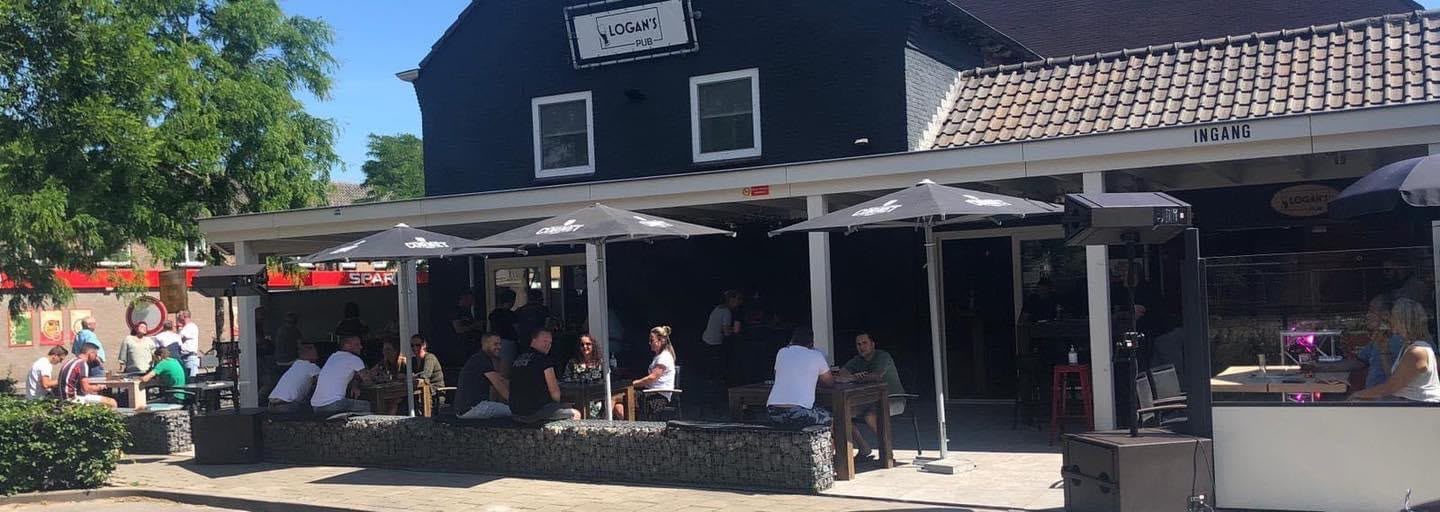Het overdekte terras van Logan's Pub aan de Berglarenstraat, gasten onder de parasols